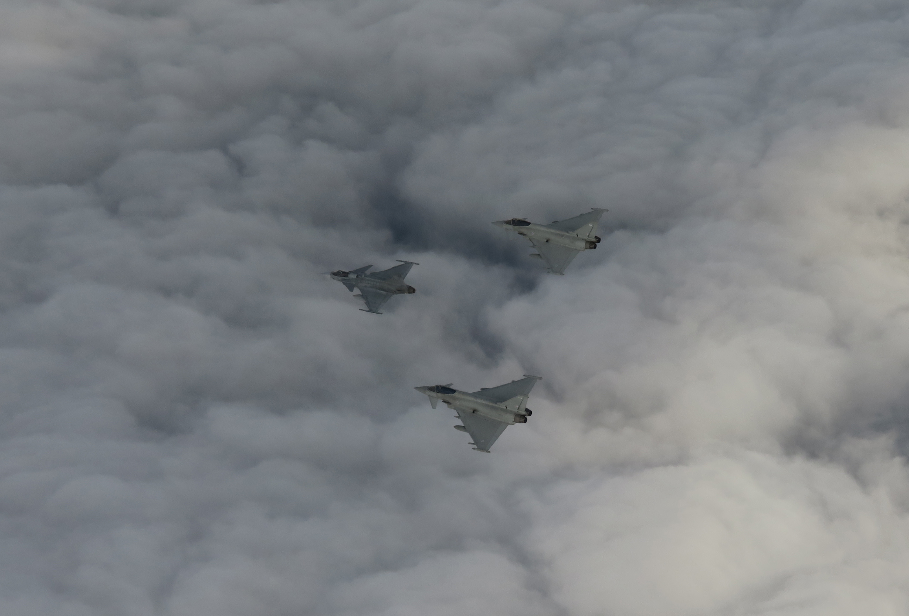 Image shows three Typhoons flying through the clouds in formation.
